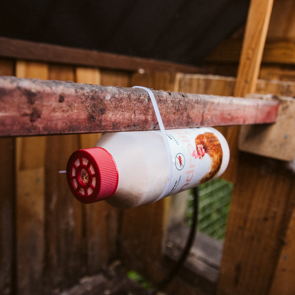 Fles Androlis hangt aan balk in kippenhok